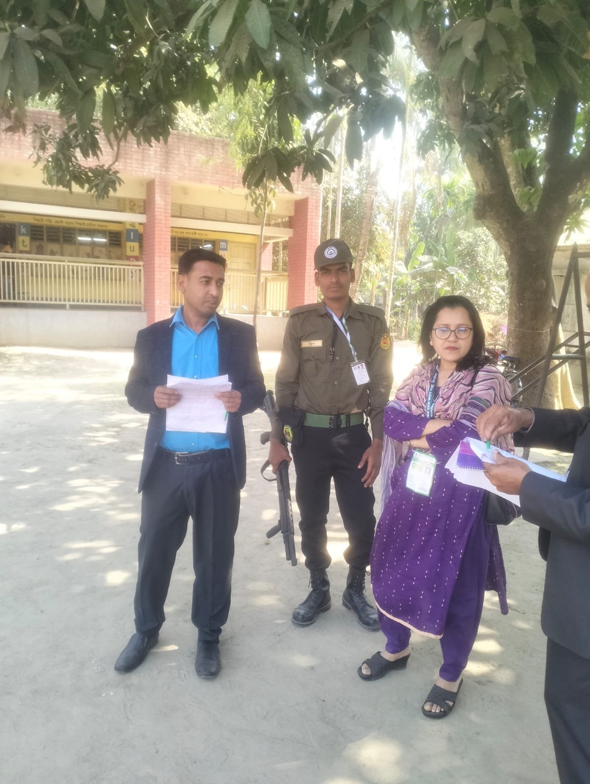 People with documents outdoors (officials and a woman).